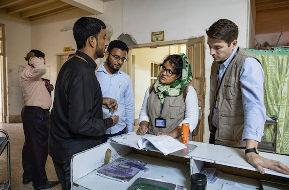Nahreen Ahmed speaking with team members in a Yemen medical facility